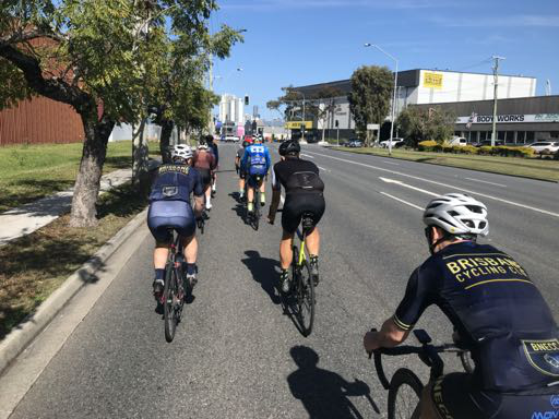 A group of cyclists riding together on an open road